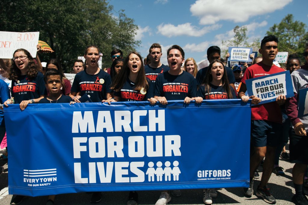 a group of protesters behind a sign that reads 'march for our lives'