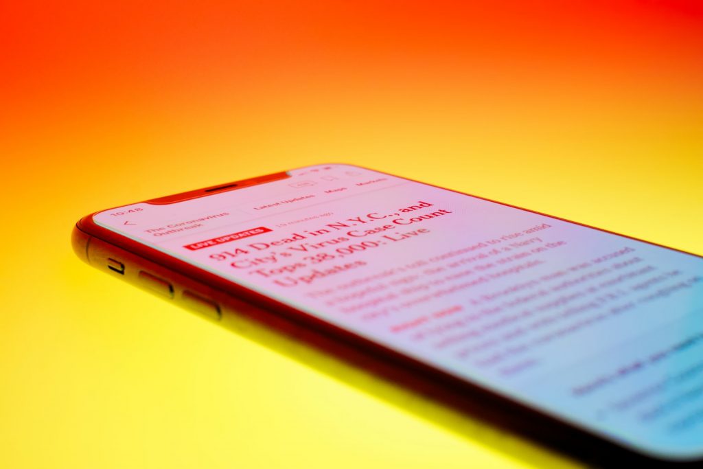 A news headline on a smartphone on an orange background