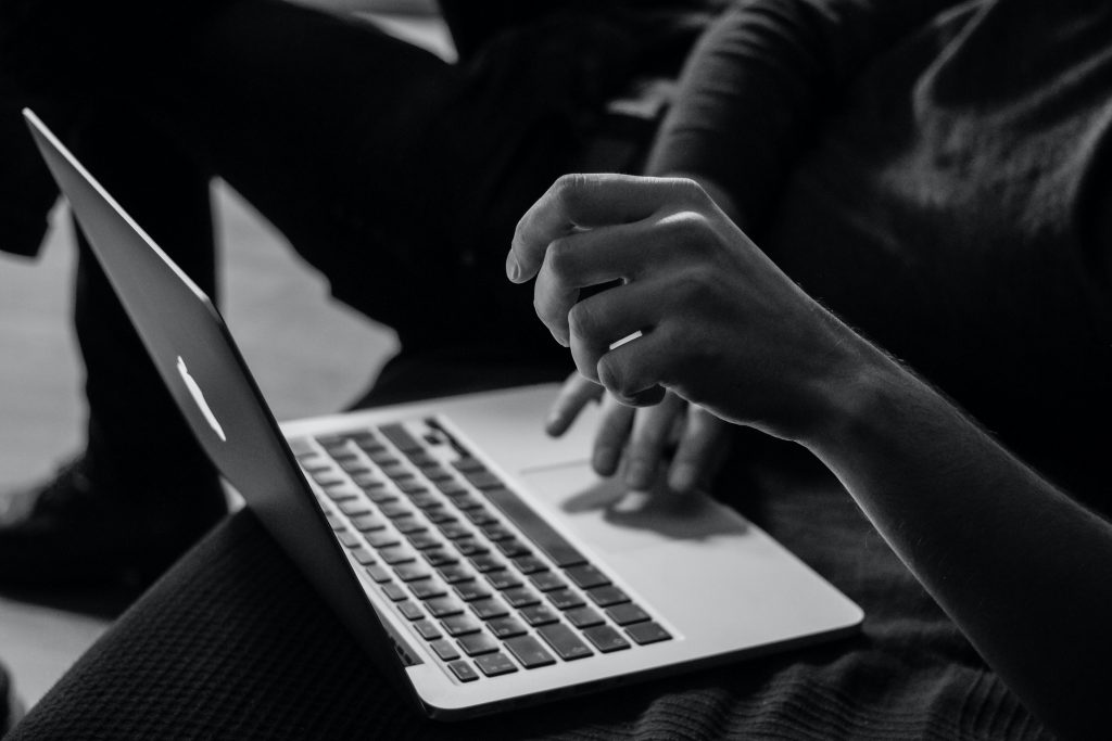 A black and white photo of someone using a laptop